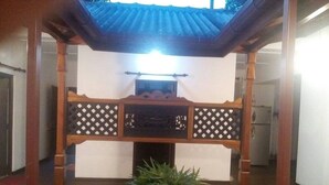 A traditional Japanese-style room with tatami flooring, a shoji screen, and a small indoor garden.