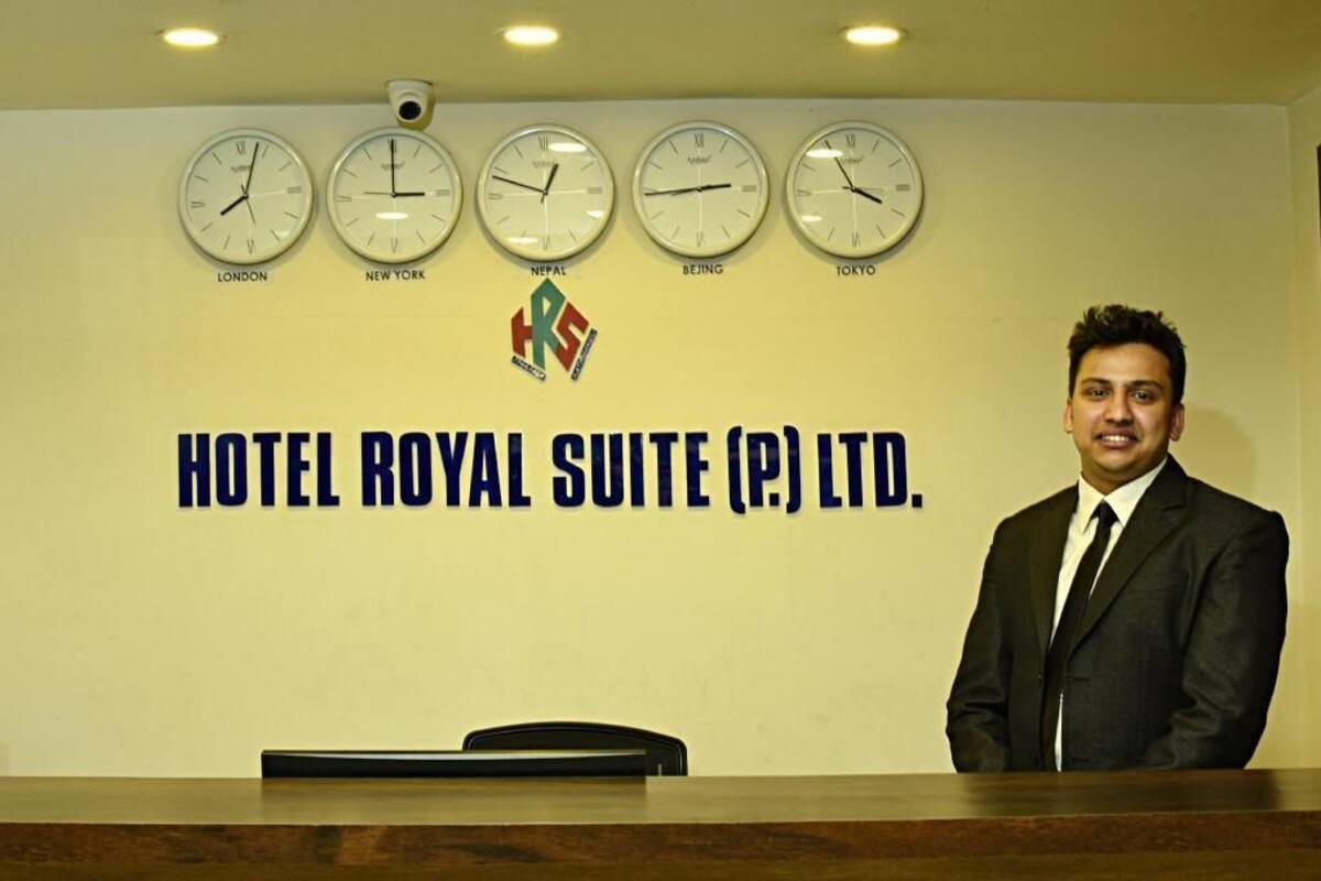Una recepción de hotel con relojes que muestran la hora de Londres, Nueva York, Nepal, Pekín y Tokio.