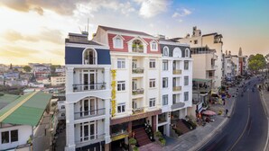 Un hotel de varios pisos con un cartel llamativo, balcones y vista a la calle.