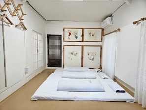 A room with a bed, a wardrobe, a window, and a door.