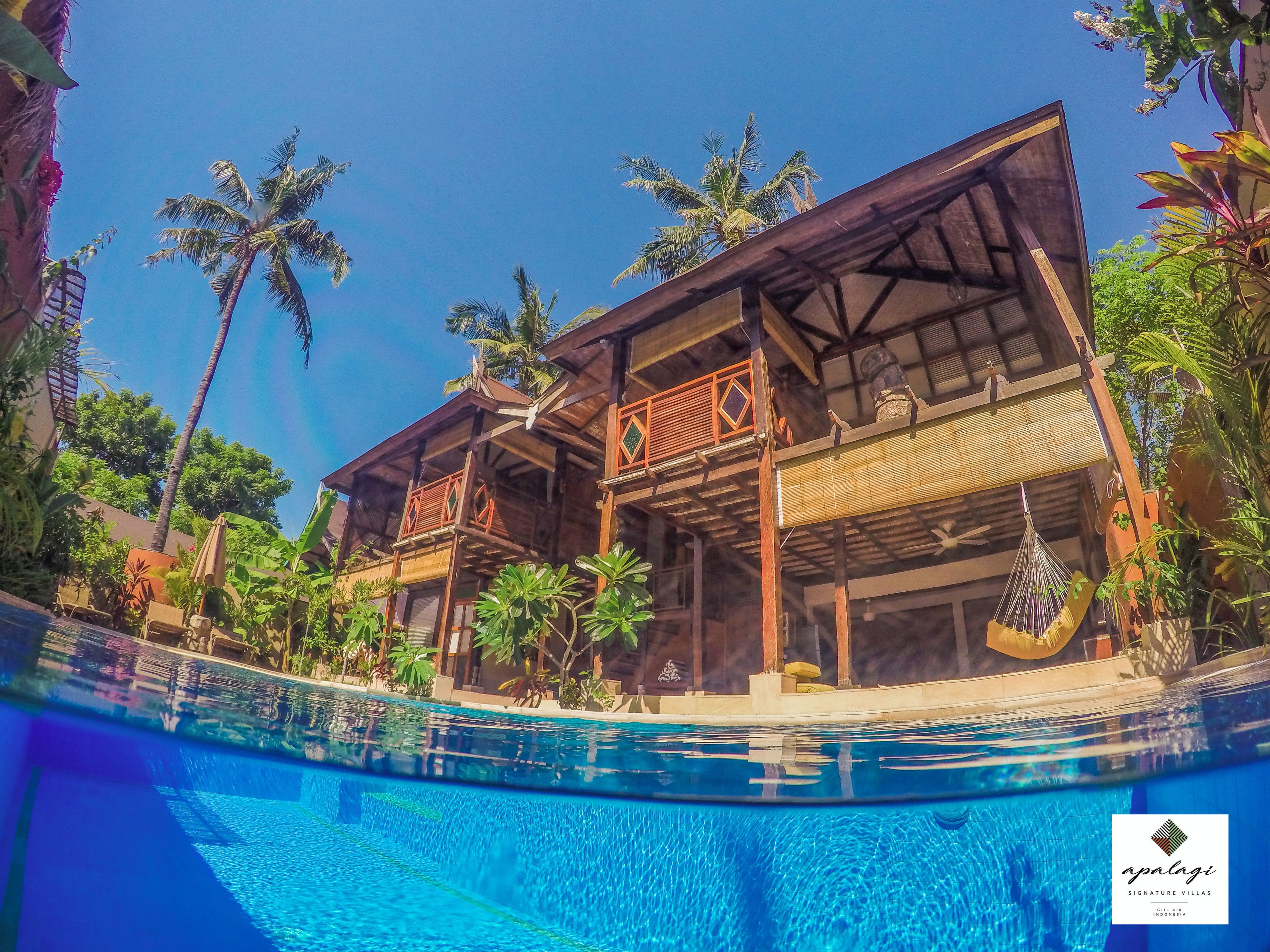 A two-story wooden building with a pool in front.