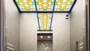 An elevator with a patterned ceiling, a carpet with the hotel's logo, and a mirrored wall. - SARASA HOTEL Shin-Osaka (Osaka)