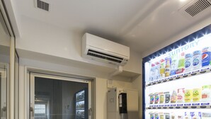 A vending machine with a Pepsi logo, a window, and an air conditioning unit on the wall. - SARASA HOTEL Shin-Osaka (Osaka)