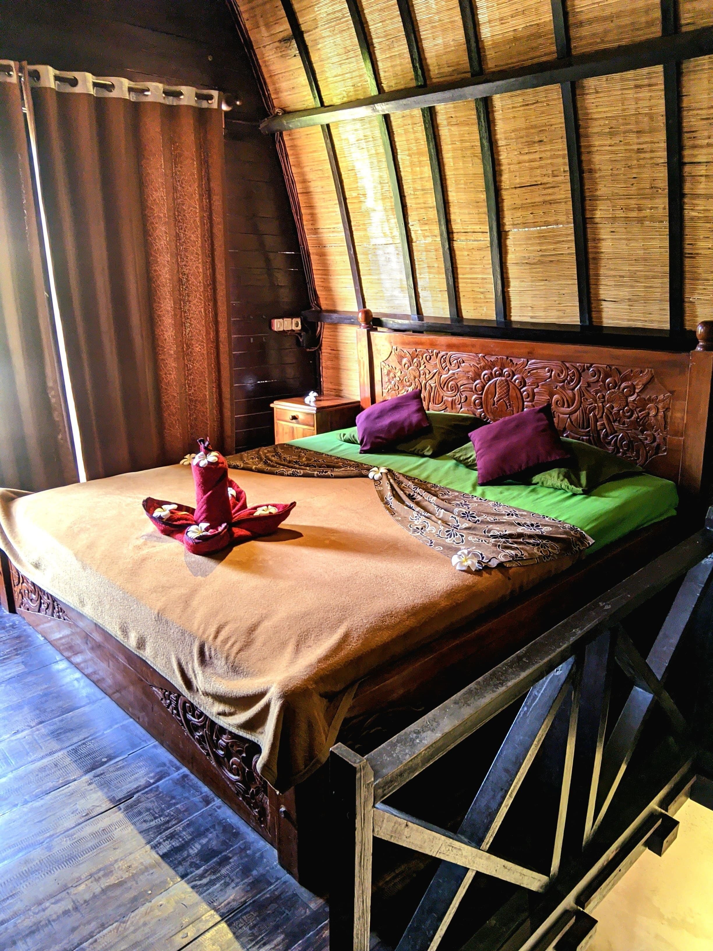 A traditional room with a bed, a nightstand, and a wooden headboard.