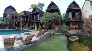 A resort with multiple chalet-style buildings, a swimming pool, outdoor seating, and a small pond. - Bale Sasak (Gili Trawangan)