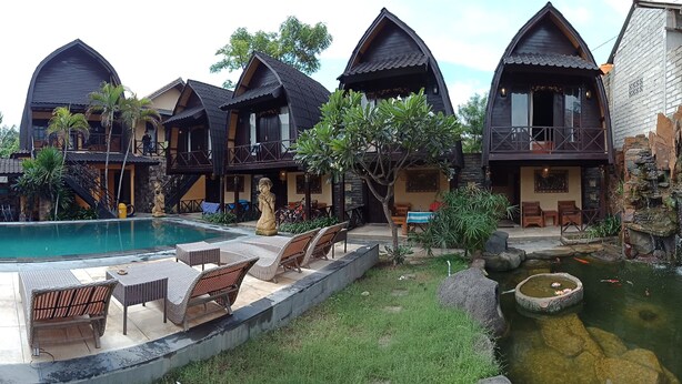 A resort with multiple chalet-style buildings, a swimming pool, outdoor seating, and a small pond. - Bale Sasak (Gili Trawangan)