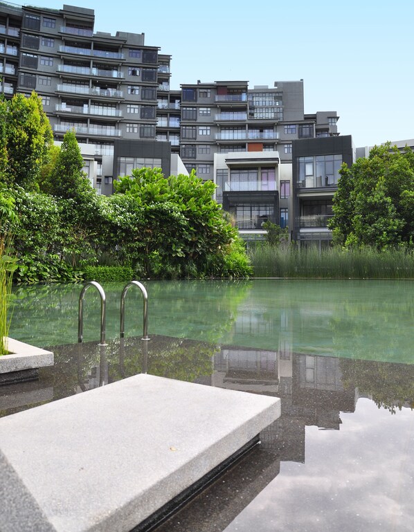 A modern residential building with balconies and a clear pool area. - Pinebox Mirage by the Lake (Cyberjaya)