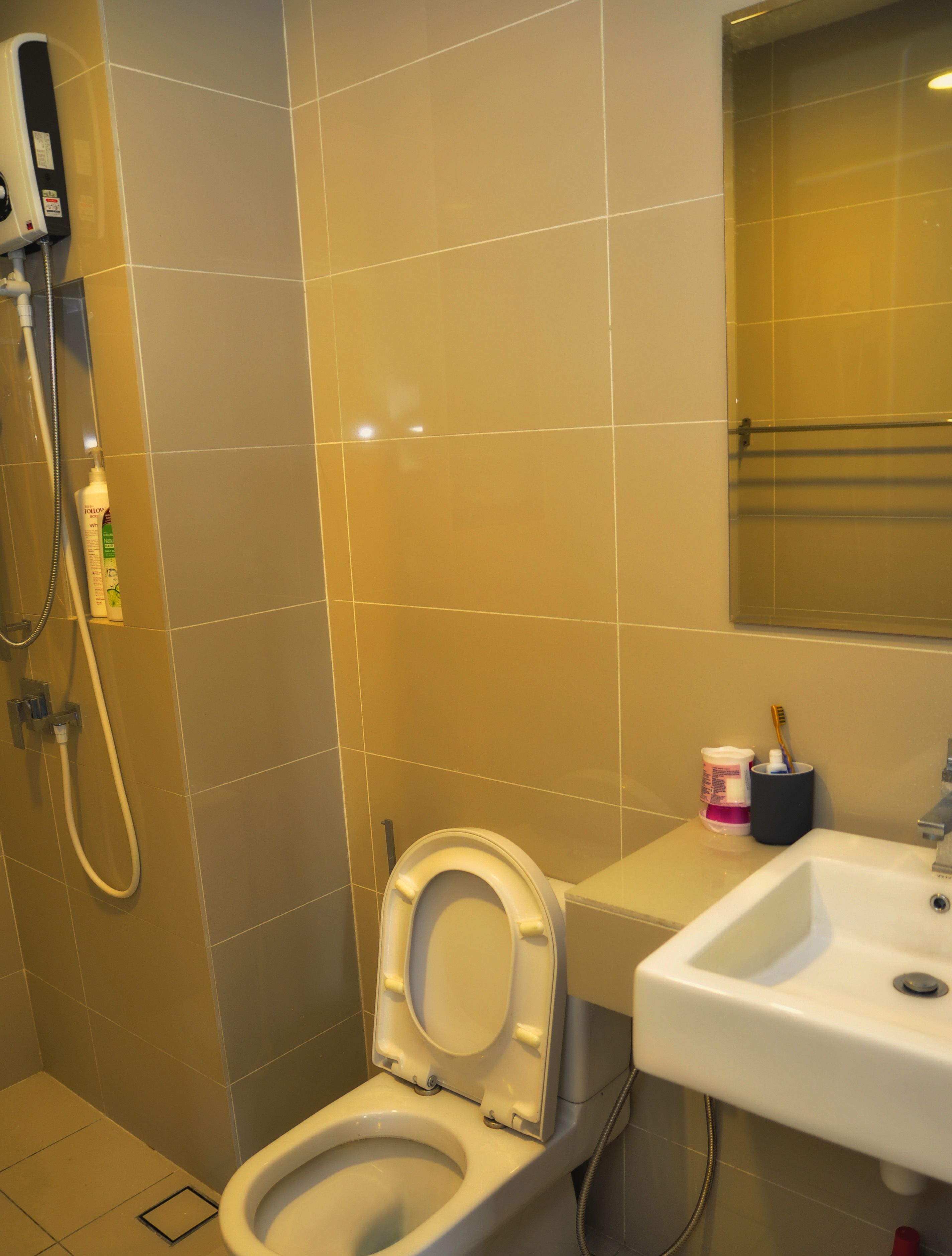 A bathroom with a toilet, sink, and shower.