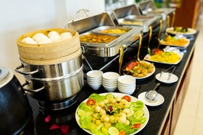 A buffet with various dishes, including a pot of dumplings and a salad. - Navy Hotel Danang (Da Nang)