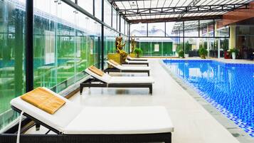 Una piscina techada, sillones reclinables de piscina