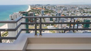 Ein Balkon mit zwei Barhocker, der Blick auf eine Küstenstadt bietet.
