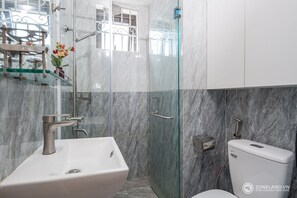 Ein Badezimmer mit Duschkabine, weißem Waschbecken und Toilette.