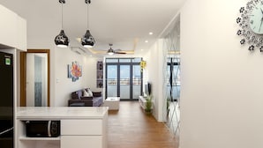 Eine moderne Küche mit integriertem Mikrowellenherd, einem Essbereich mit Sofa und Tisch sowie Stadtblick durch große Fenster.