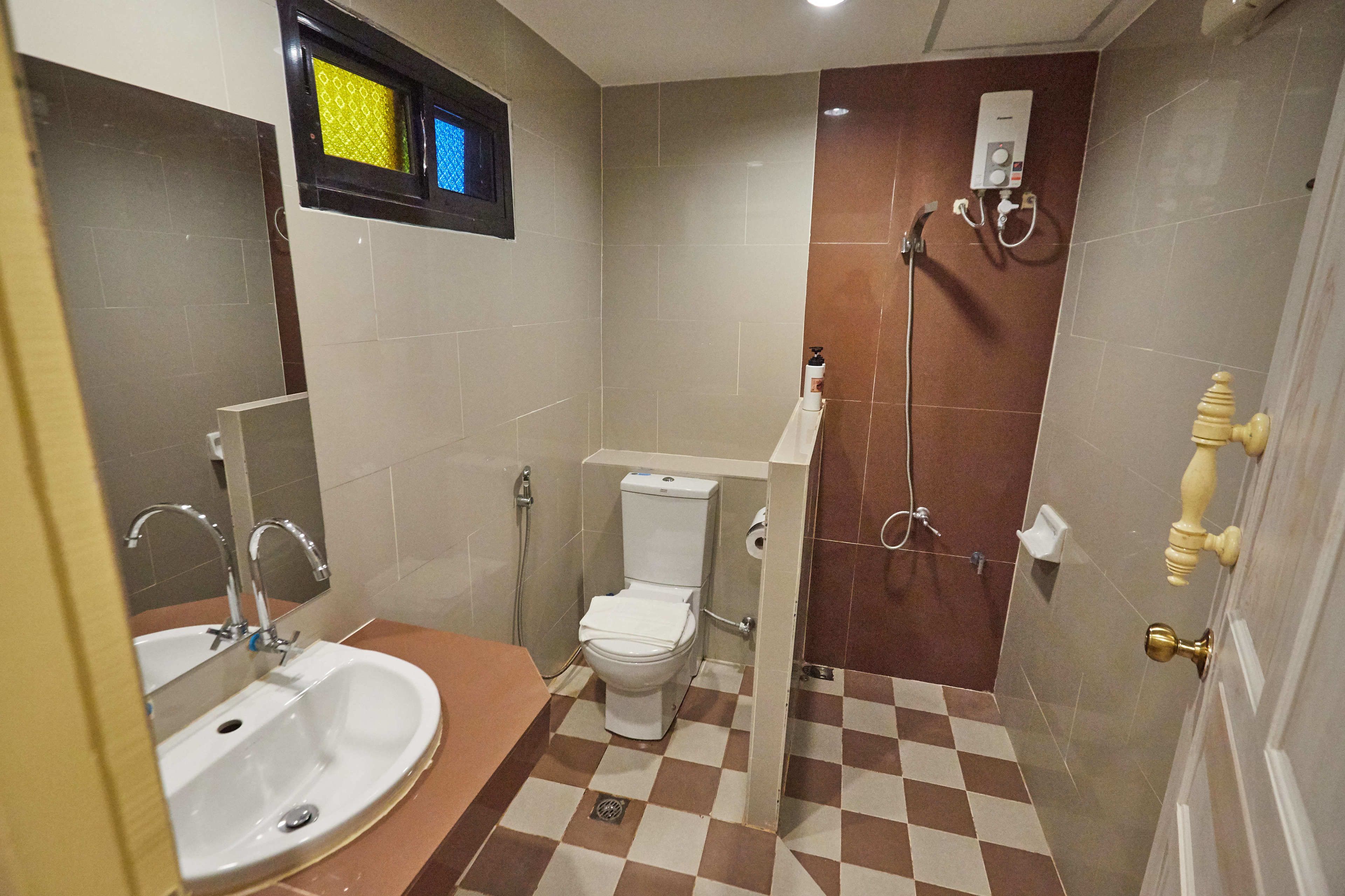 A compact bathroom with a sink, toilet, and shower.