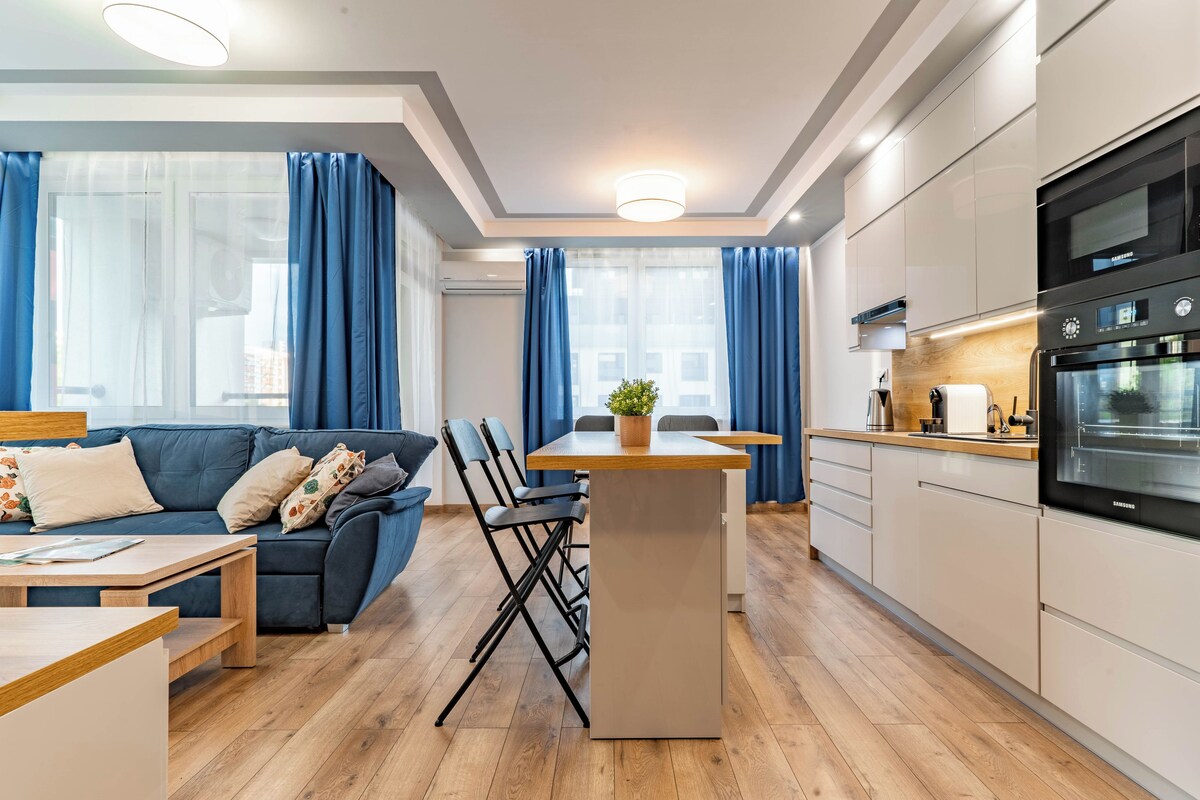 A modern apartment with a living area, kitchen, and dining space.