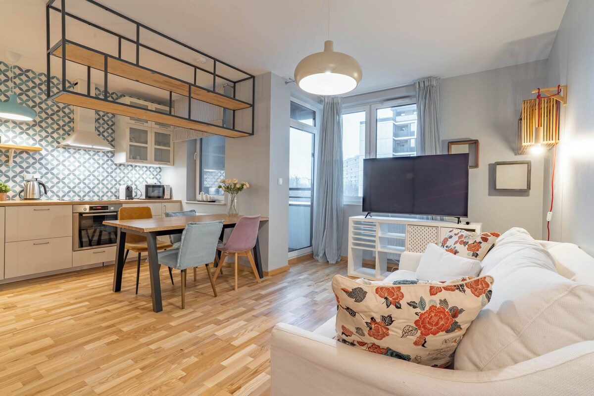 A modern apartment with a kitchen, dining area, and living room.