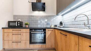 A modern kitchen with a built-in oven, microwave, and a stainless steel sink.