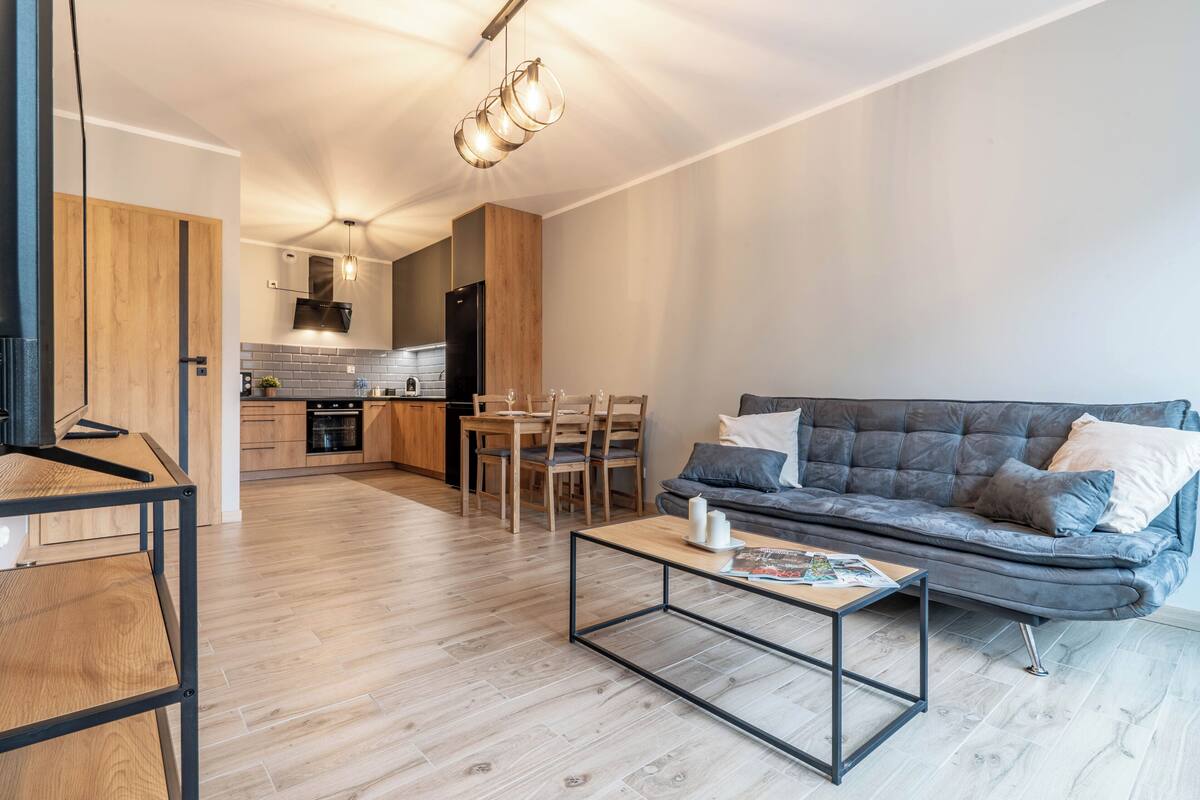 Una sala de estar moderna con un sofá, una mesa de centro y un comedor.