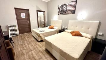 A hotel room with two beds, a radiator, a door with a sign, and a wall-mounted clock.