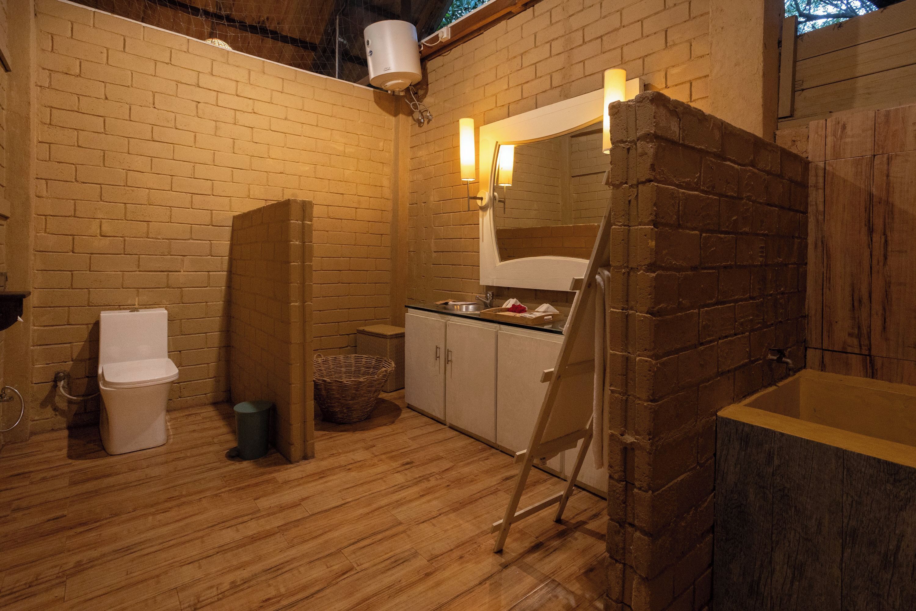 A bathroom with a wooden floor, a white toilet, a sink, and a mirror.