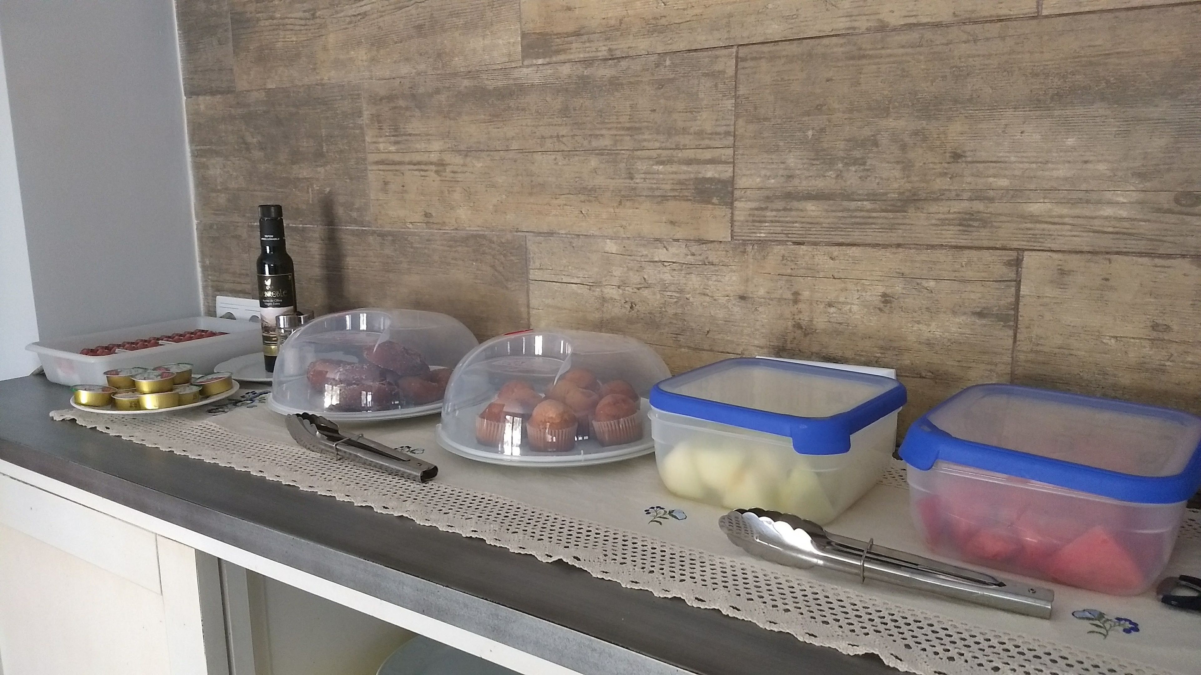 Una encimera de cocina con alimentos en recipientes, un cuchillo y una botella.