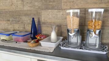 Una encimera de cocina con recipientes de almacenamiento, una botella y dos dosificadores de comida.