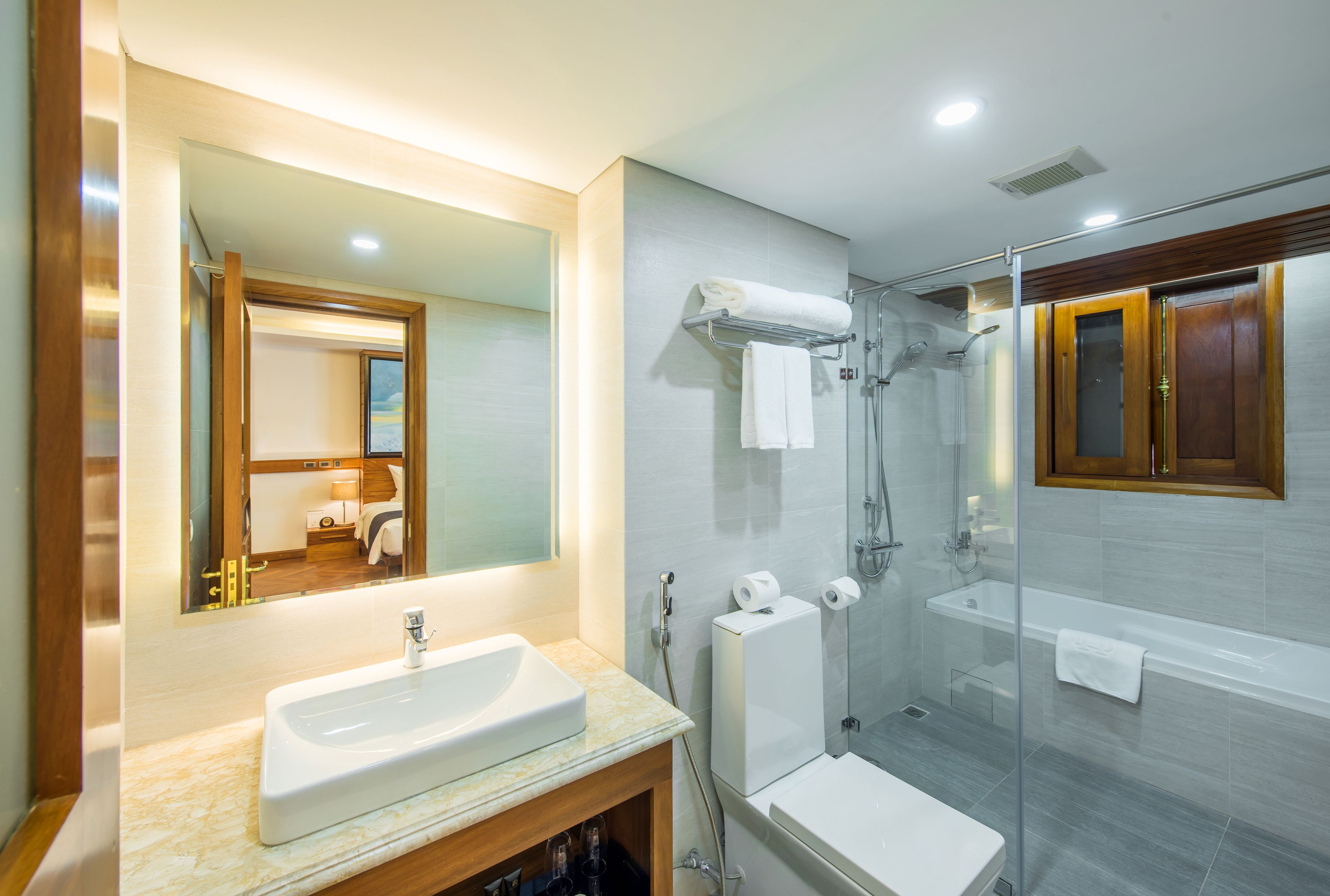 A modern bathroom with a large mirror, a sink, a shower, and a bathtub.