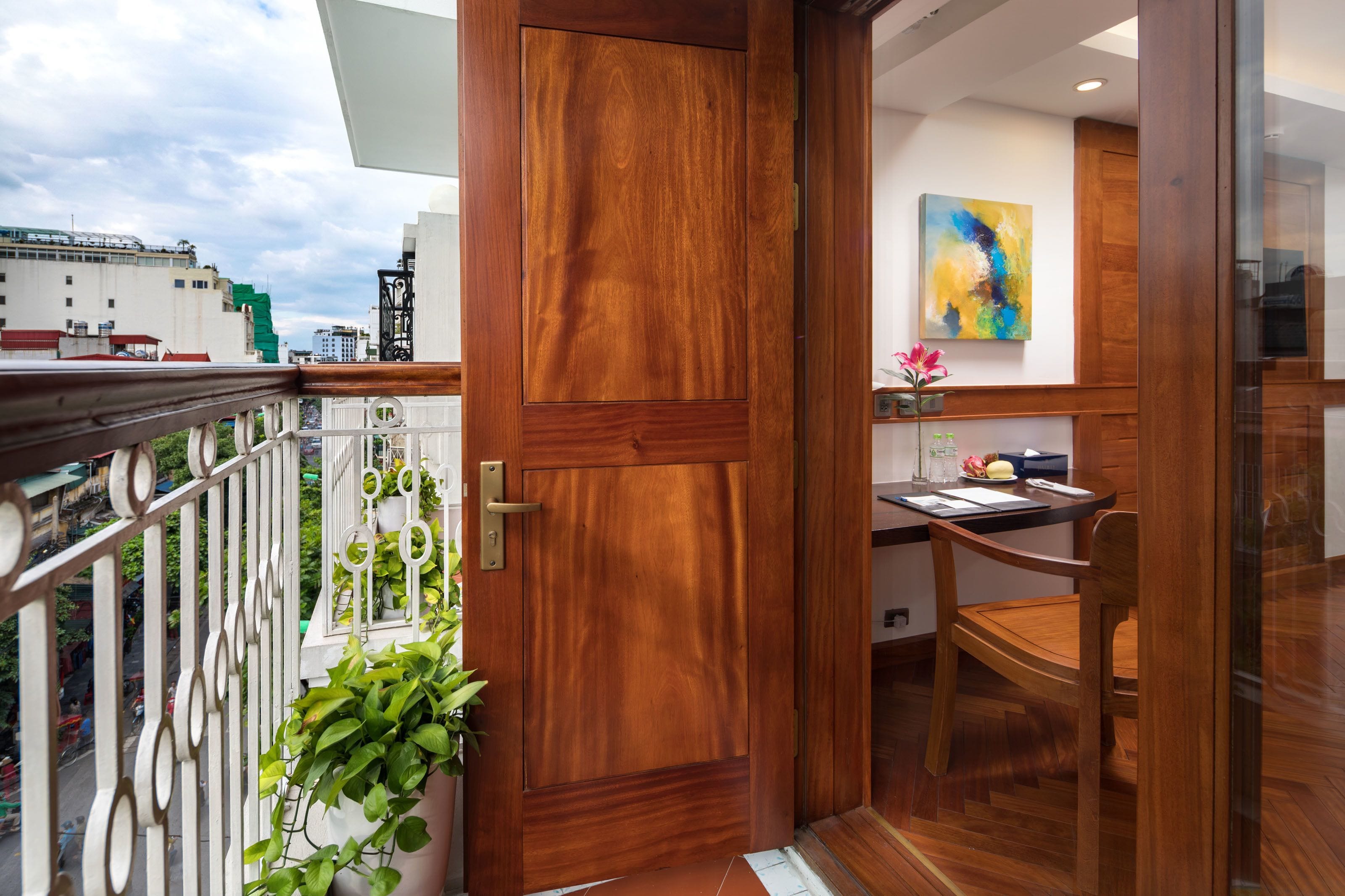 A wooden door leading to a kitchen with a dining table and chairs.