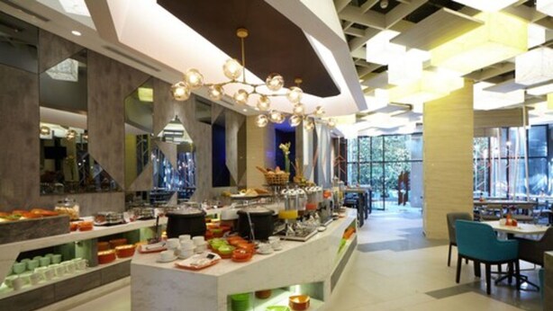 A modern breakfast bar with various food items and a seating area with chairs. - ibis Styles Medan Pattimura (Medan)
