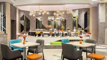 A modern dining area with a central buffet, multiple seating arrangements, and contemporary lighting fixtures.