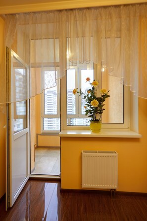 A room with a window, a radiator, and a yellow wall.