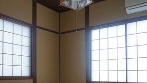Um quarto japonês tradicional com tatames, uma mesa de madeira baixa e um futon.