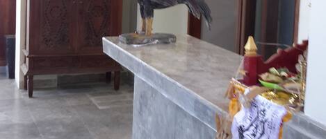 A marble counter with a decorative rooster and a statue of a figure.