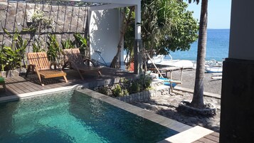 Una piscina al aire libre, sillones reclinables de piscina