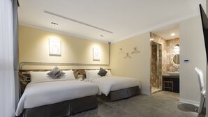 A hotel room with two beds, a bathroom with a shower, and a small sitting area. - Napas Hotel (Taichung)
