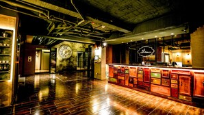 A spacious bar area with a polished wooden floor, a large clock, and a well-lit bar counter. - Napas Hotel (Taichung)