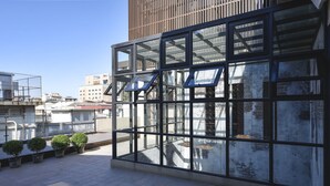 A modern building with large glass windows and a metal framework. There are potted plants along the walkway. - Napas Hotel (Taichung)