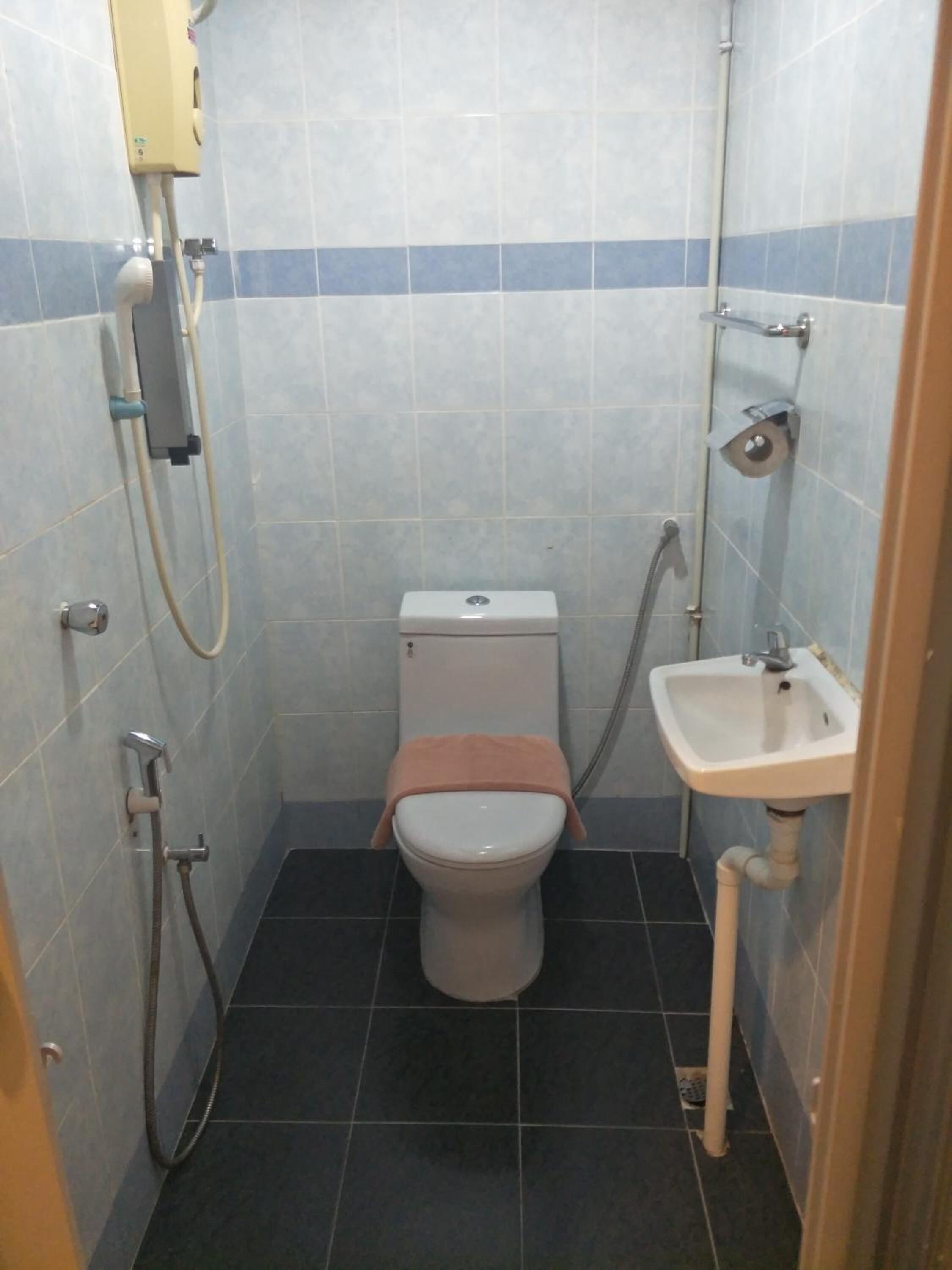 Ein kleines, kompaktes Badezimmer mit Toilette, Waschbecken und Dusche.