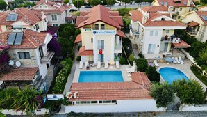 A residential building with a swimming pool, solar panels, and a flag. - Karaca Apart Hotel (Ortaca)