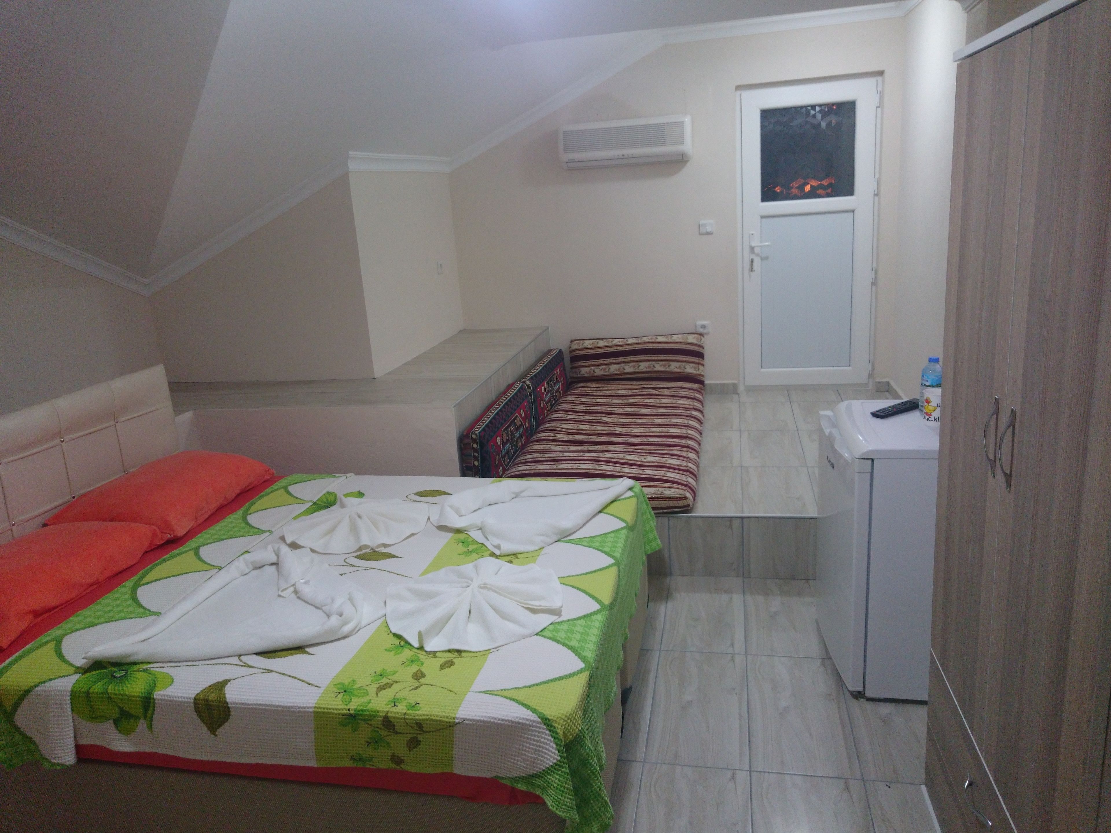 Une chambre à coucher comprenant un lit, un canapé, un lave-linge et une armoire.