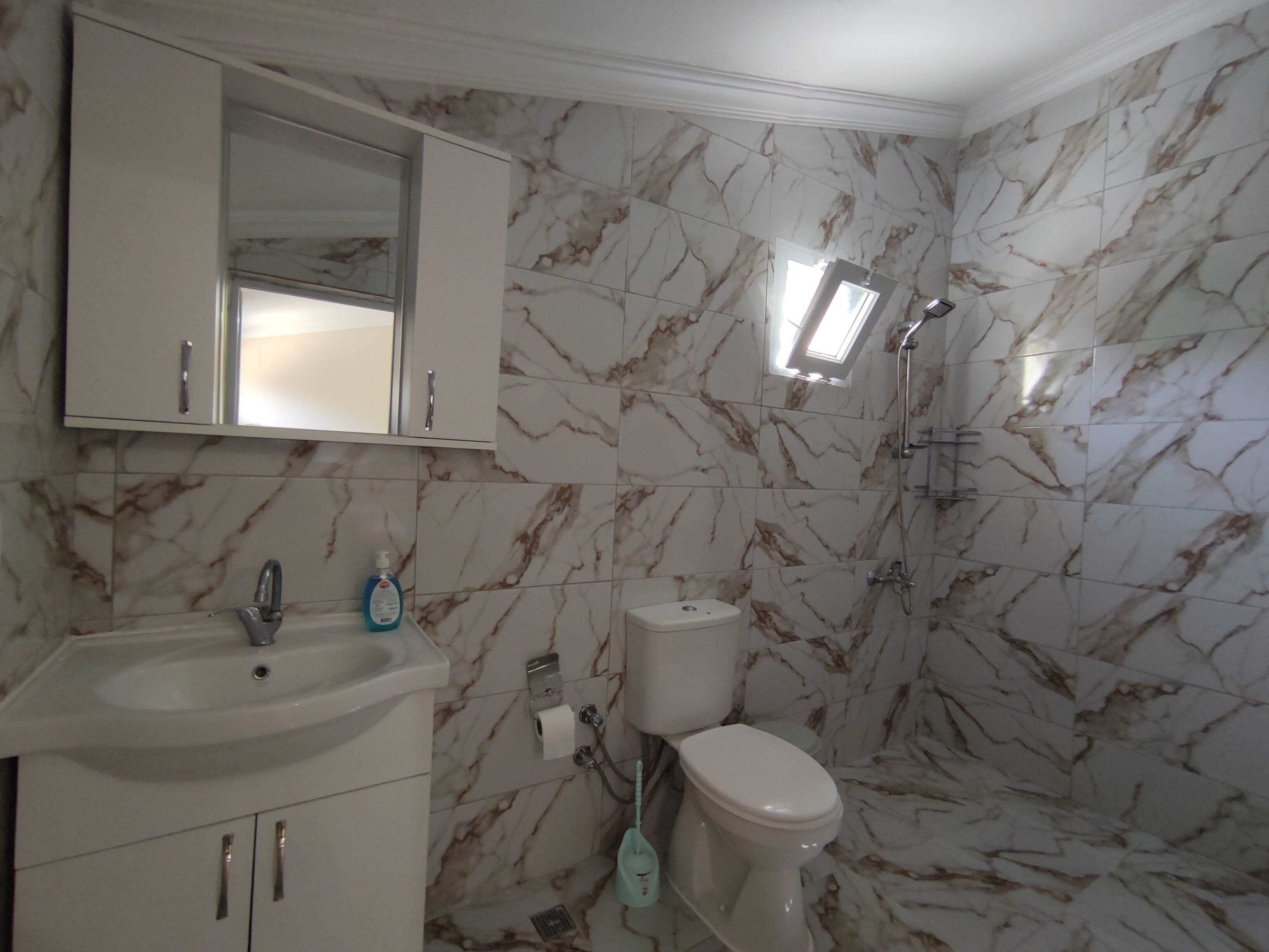 A bathroom with a sink, toilet, and shower.