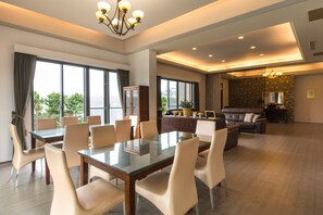 A spacious living area with a dining table, comfortable seating, and a view of the outdoors. - Shui Lian Tian Villa (Wujie)