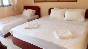 Une chambre d’hôtel avec deux lits, chacun étant équipé de draps et d’oreillers blancs.