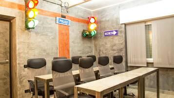 Une salle de conférence avec une longue table, de nombreuses chaises, un panneau indiquant « POLICE », un panneau indiquant « SENS UNIQUE » et des feux de signalisation.