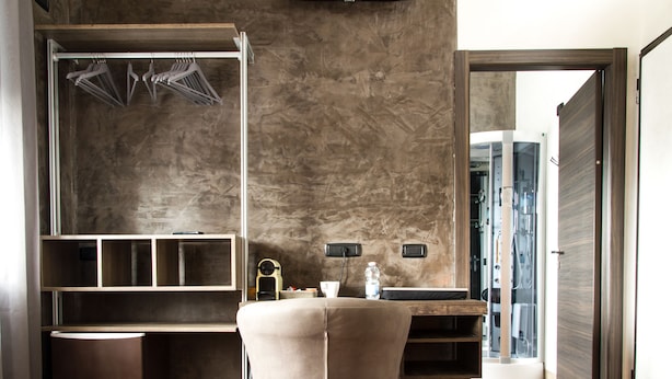 Una habitación moderna con armario empotrado, un escritorio pequeño con silla y un espejo grande.