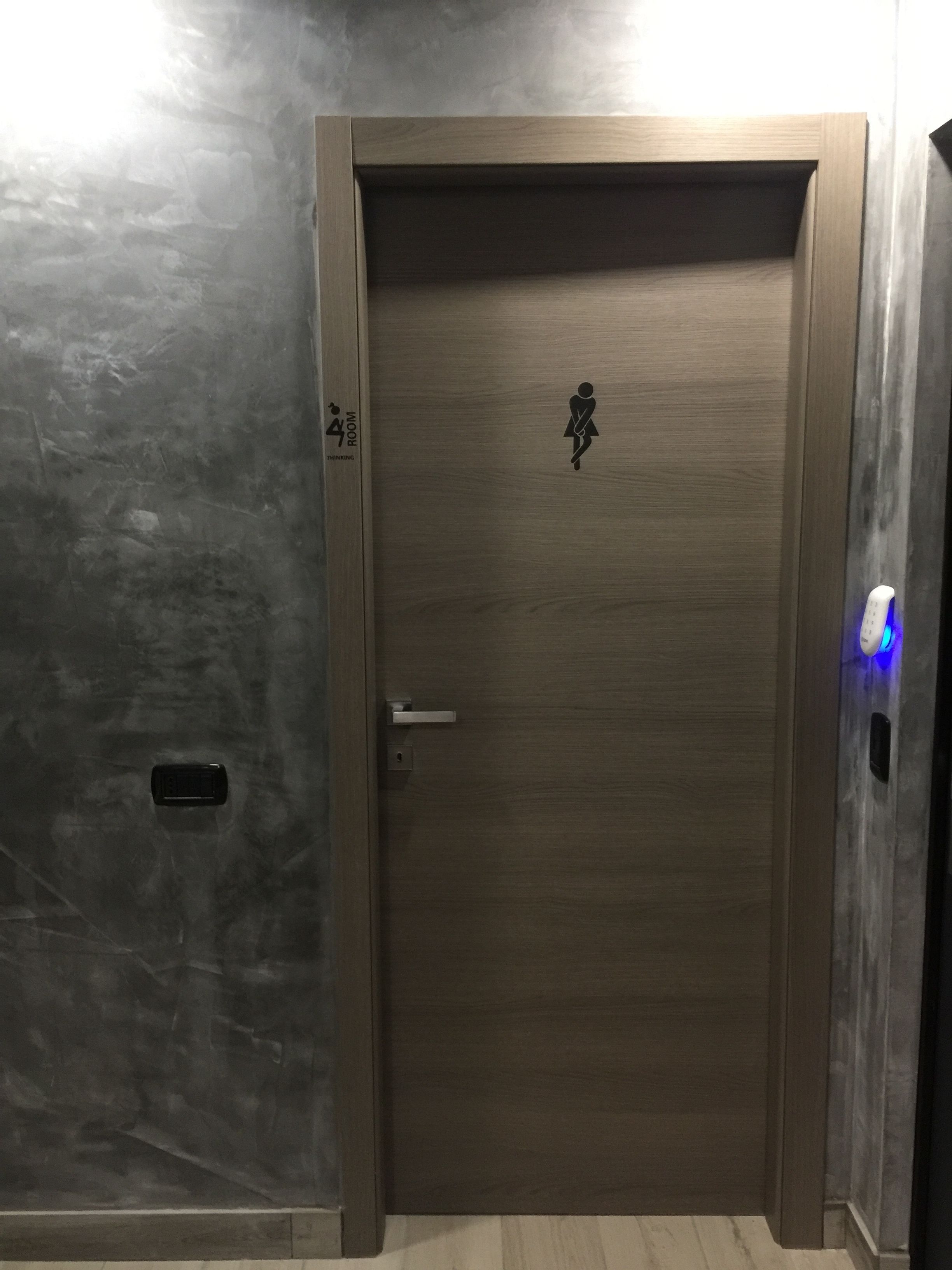 A wooden door with a small window and a doorbell.