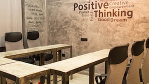 Un salón de conferencias con una nube de palabras en la pared y citas motivacionales.