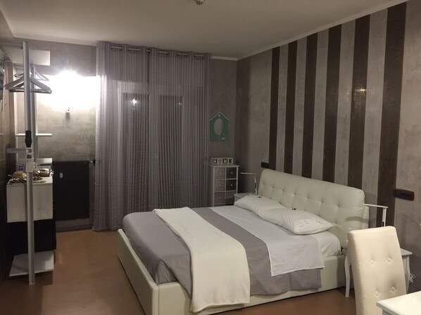 A bedroom with a bed, a desk, a chair, and a wardrobe. - B2in Suite & Office (Capriate San Gervasio)