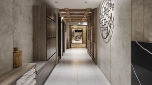A corridor with a wooden bench, a wall-mounted decorative piece, and a tiled floor. - Dar Lon Hotel (Hsinchu)