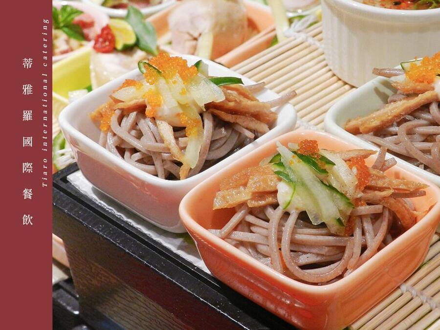 Una mesa con cuencos de fideos cubiertos de huevas de pescado y verduras.